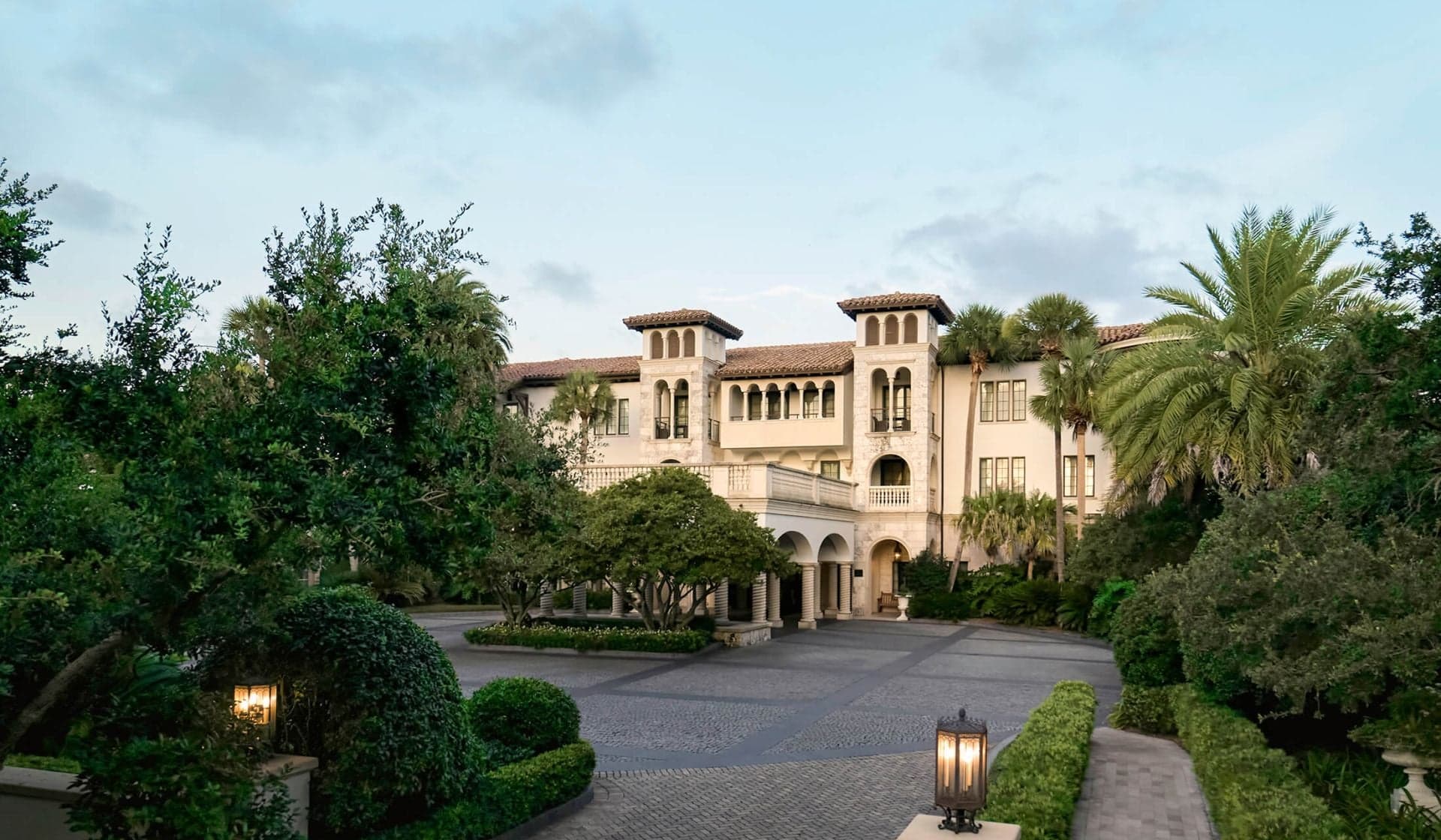 The Cloister at Sea Island exterior framed by palms.
